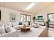 Bright living room with a skylight, white sectional sofa, and modern decor at 8159 Lodgepole Trl, Lone Tree, CO 80124