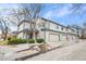 Townhome with a two-car garage, a sidewalk and greenery, and a brick facade at 4301 S Pierce St # 5B, Littleton, CO 80123