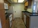 Bright kitchen featuring tile floors, wood cabinets, black countertop and appliances at 431 S Kalispell Way # 308, Aurora, CO 80017