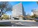Exterior view of a modern high-rise building with a glass entrance and surrounding landscaping on a sunny day at 789 N Clarkson St # 906, Denver, CO 80218
