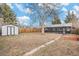 A large backyard featuring a storage shed, a tall tree, and enclosed sunroom at 1575 Verbena St, Denver, CO 80220