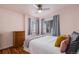 Cozy bedroom with hardwood floors, a ceiling fan, and natural light from the windows at 1575 Verbena St, Denver, CO 80220