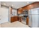 Modern kitchen featuring stainless steel appliances, granite countertops, and wood cabinets at 1575 Verbena St, Denver, CO 80220