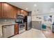 Modern kitchen featuring stainless steel appliances, granite countertops, and wood cabinets at 1575 Verbena St, Denver, CO 80220