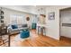 Bright living room featuring hardwood floors, a comfortable sofa, and a stylish blue tufted ottoman at 1575 Verbena St, Denver, CO 80220