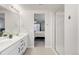 Bright bathroom featuring double sinks, quartz countertops, and a glass-enclosed shower at 1845 Meagan Way, Erie, CO 80516