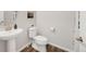 Bright bathroom with a pedestal sink, modern toilet, and neutral paint at 1845 Meagan Way, Erie, CO 80516
