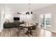 Inviting dining area adjacent to the living room featuring modern lighting and a view to the patio at 1845 Meagan Way, Erie, CO 80516