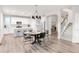 Open-concept dining area next to the kitchen and stairs, featuring modern lighting and wood floors at 1845 Meagan Way, Erie, CO 80516