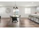 Dining area features hardwood floors, a stylish chandelier and an eye-catching clock at 1845 Meagan Way, Erie, CO 80516