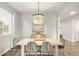 Stylish dining room with modern chandelier, wood floors, a buffet, and a large window at 1845 Meagan Way, Erie, CO 80516