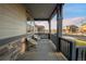 Inviting covered front porch with stone accents, seating, and views of the neighborhood street at 1845 Meagan Way, Erie, CO 80516