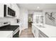 Modern kitchen featuring stainless steel appliances, white cabinetry, and an island with a sink at 1845 Meagan Way, Erie, CO 80516