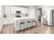 Modern kitchen features white cabinets, stainless steel appliances, and an island with bar stool seating at 1845 Meagan Way, Erie, CO 80516