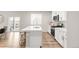 Bright kitchen with white cabinets, stainless steel appliances, a kitchen island and a dining area visible at 1845 Meagan Way, Erie, CO 80516