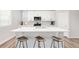 Stylish kitchen island boasts white countertops, bar stools, and modern appliances for a functional cooking space at 1845 Meagan Way, Erie, CO 80516