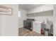 Well-organized laundry room featuring modern washer and dryer, sink, shelving, and ample storage space at 1845 Meagan Way, Erie, CO 80516