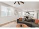 Open-concept living room showcases a gray sectional sofa, dining area and a modern clock on the wall at 1845 Meagan Way, Erie, CO 80516