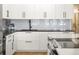 Close-up of a modern kitchen showcasing white cabinetry, black hardware, and a stylish backsplash at 1499 Blake St # 3M, Denver, CO 80202