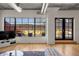 Bright living area with hardwood floors, large windows leading to a terrace, and exposed industrial ductwork at 1499 Blake St # 3M, Denver, CO 80202
