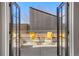 This patio has 2 comfortable chairs with bright yellow pillows, and concrete flooring at 1499 Blake St # 3M, Denver, CO 80202