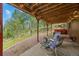 Serene backyard patio with wooded views, seating area, and outdoor bar at 32462 Lodgepole Dr, Evergreen, CO 80439