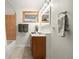 Bright bathroom featuring a shower/tub, vanity, neutral tile, and window at 32462 Lodgepole Dr, Evergreen, CO 80439