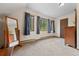 Bright bedroom featuring three windows dressed with blue curtains and plush carpeting at 32462 Lodgepole Dr, Evergreen, CO 80439