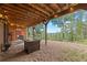 Covered back patio with fire pit, seating, and views of surrounding trees at 32462 Lodgepole Dr, Evergreen, CO 80439
