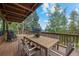 Enjoy outdoor dining on this expansive deck with lush green scenery and distant views at 32462 Lodgepole Dr, Evergreen, CO 80439