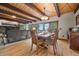 Inviting dining area features wood beams, scenic views, and seamlessly connects to the living room at 32462 Lodgepole Dr, Evergreen, CO 80439