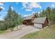 Beautiful exterior elevation of a two-story home with an attached garage, driveway, and lush landscaping at 32462 Lodgepole Dr, Evergreen, CO 80439