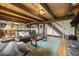 Spacious living room featuring a leather sofa, wood beams, and stairs leading to the second floor at 32462 Lodgepole Dr, Evergreen, CO 80439
