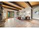 Open-concept living room with tile floors, wood-beamed ceiling, and walk-out to a deck at 32462 Lodgepole Dr, Evergreen, CO 80439