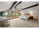 Spacious main bedroom with vaulted ceiling, exposed beams, scenic views, and balcony access at 32462 Lodgepole Dr, Evergreen, CO 80439