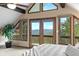 Light-filled bedroom features scenic views from large windows and balcony, blending indoor/outdoor living at 32462 Lodgepole Dr, Evergreen, CO 80439