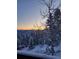 Spectacular mountain views with snow-covered pine trees as seen from the porch at sunset at 32462 Lodgepole Dr, Evergreen, CO 80439