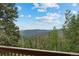 Breathtaking mountain views from the deck, surrounded by lush forest and clear blue skies at 32462 Lodgepole Dr, Evergreen, CO 80439