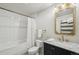 This bathroom features a shower/tub combo with white subway tile and a black vanity with gold accents at 1801 Wynkoop St # 208, Denver, CO 80202