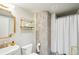 Bathroom featuring decorative mirror, modern fixtures, and a shower with white tiles at 1801 Wynkoop St # 208, Denver, CO 80202