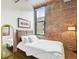 Bedroom showcasing exposed brick accent wall, hardwood flooring, and a cozy, comfortable bed at 1801 Wynkoop St # 208, Denver, CO 80202