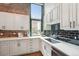 Kitchen with white cabinets, subway tile backsplash, stainless steel sink, modern fixtures, and large window at 1801 Wynkoop St # 208, Denver, CO 80202