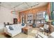 Bright living room featuring exposed brick, ductwork, large windows, comfortable seating and dining area at 1801 Wynkoop St # 208, Denver, CO 80202