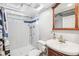 Bathroom features a glass block window, and a vanity and mirror with wood accents at 2663 King St, Denver, CO 80211