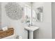 Cozy bathroom boasts a pedestal sink, decorative mirror, and natural light at 2663 King St, Denver, CO 80211