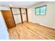 Bright bedroom with hardwood floors, large closet space, and natural light from the window at 6040 W Elmhurst Dr, Littleton, CO 80128