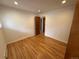 Well-lit bedroom featuring hardwood floors, neutral walls, and closet with convenient access to the hallway at 6040 W Elmhurst Dr, Littleton, CO 80128