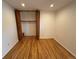 Cozy bedroom with hardwood flooring, ample closet space with bi-fold doors, and pristine white walls at 6040 W Elmhurst Dr, Littleton, CO 80128