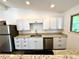Modern kitchen with white cabinetry, granite countertops, and stainless steel appliances at 6040 W Elmhurst Dr, Littleton, CO 80128