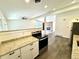 Bright kitchen featuring granite countertops, stainless steel appliances and a view of the living room at 6040 W Elmhurst Dr, Littleton, CO 80128